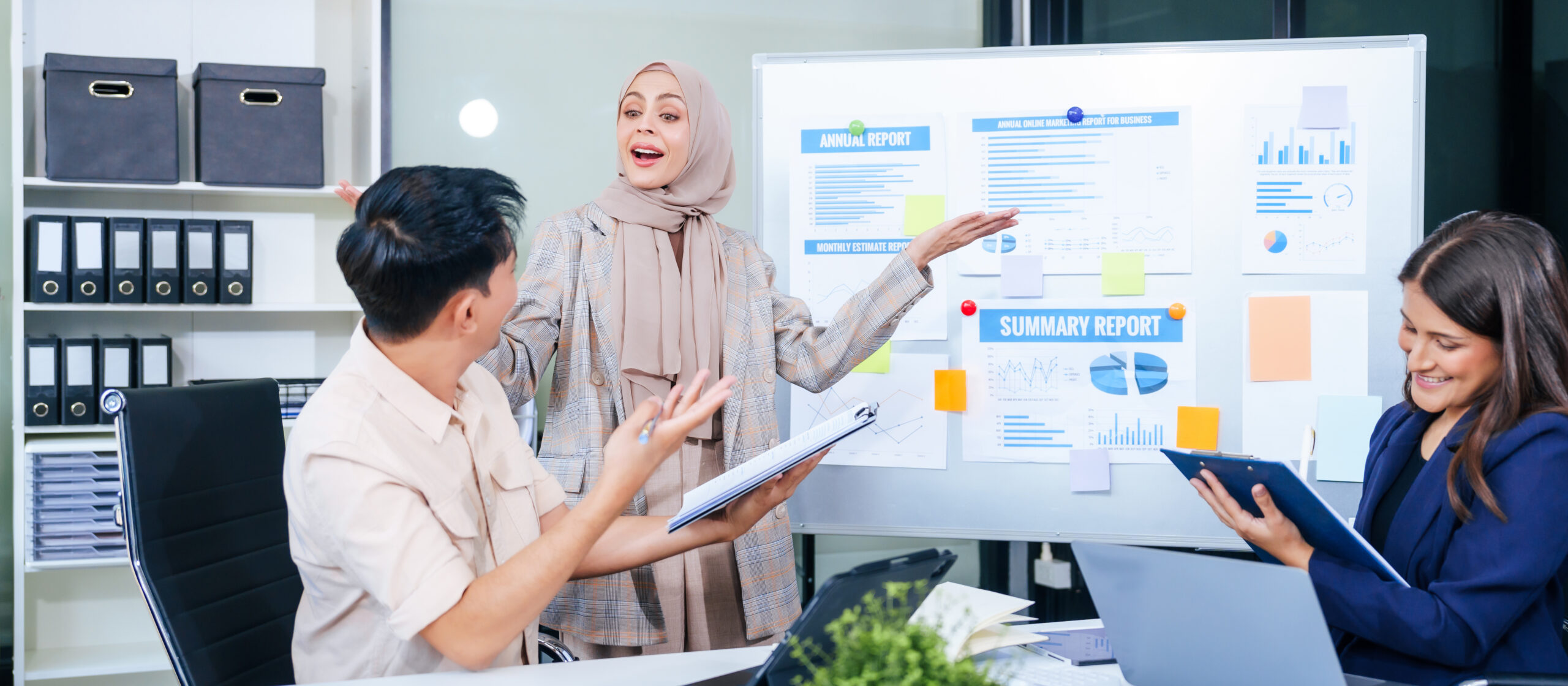 A multicultural team of professionals, including male and female businesspersons,  around a desk