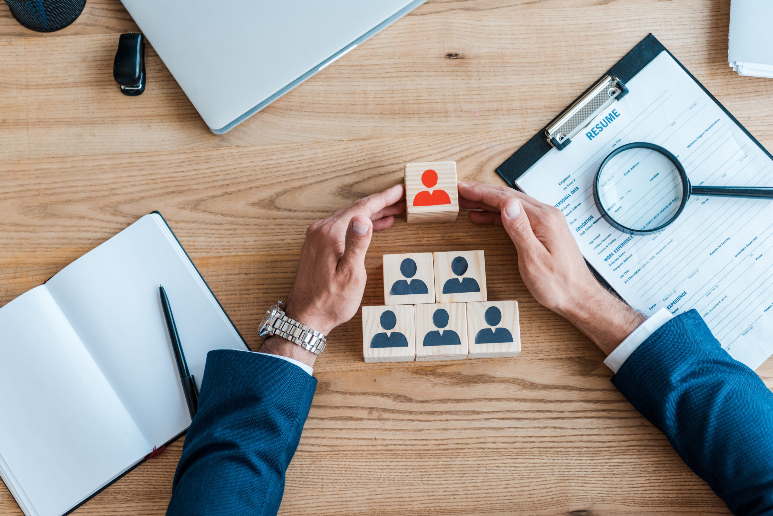 top view of recruiter near wooden cubes and clipboard on table