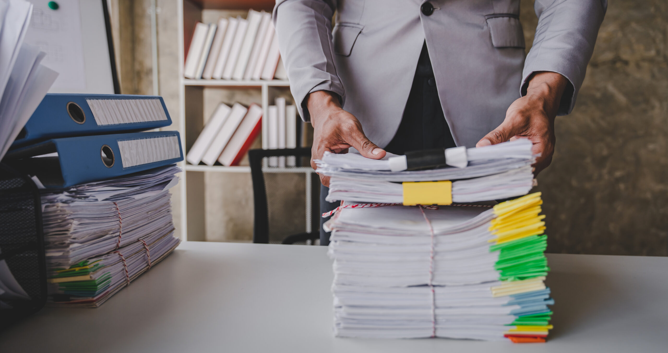 work from office A businessman works a bunch of paper files to find information on his desk at home. business report pile of unfinished documents